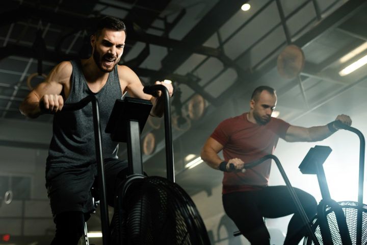 Mężczyźni na siłowni ćwiczą na maszynach