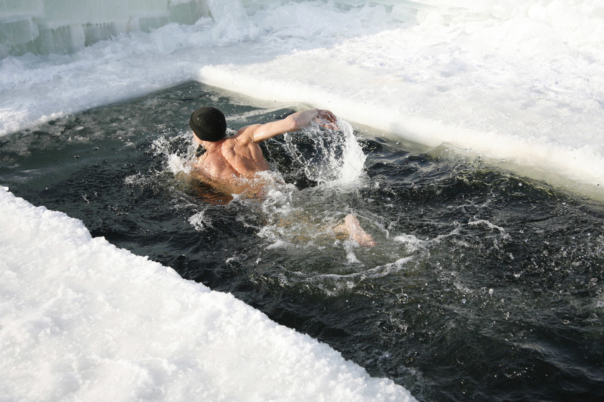 Mężczyzna pływa w lodowatej wodzie